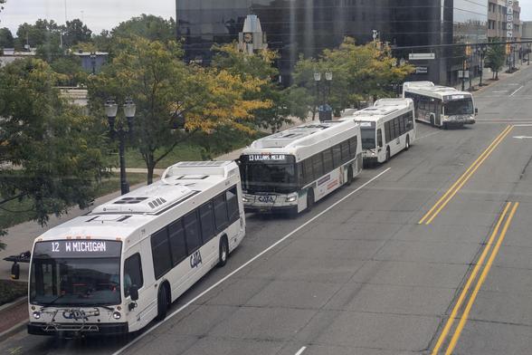 Four CATA buses traveling north on Grand seen from the Radisson skywalk